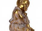 Buda bebé de resina dorada durmiendo sobre rodilla